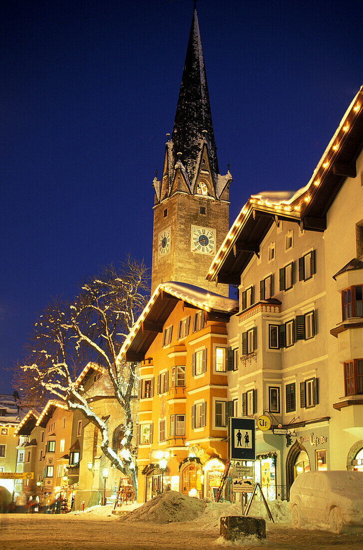 Beleuchtete Häuser und Kirchturm am Abend, Kitzbühel, Tirol, Österreich, Europa