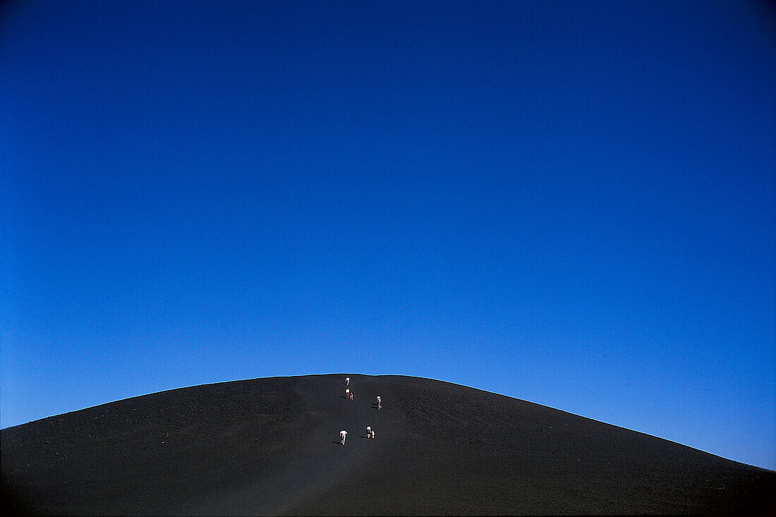 Hikers on Inferno Cone, Craters of the Moon, near Arco, Idaho, USA