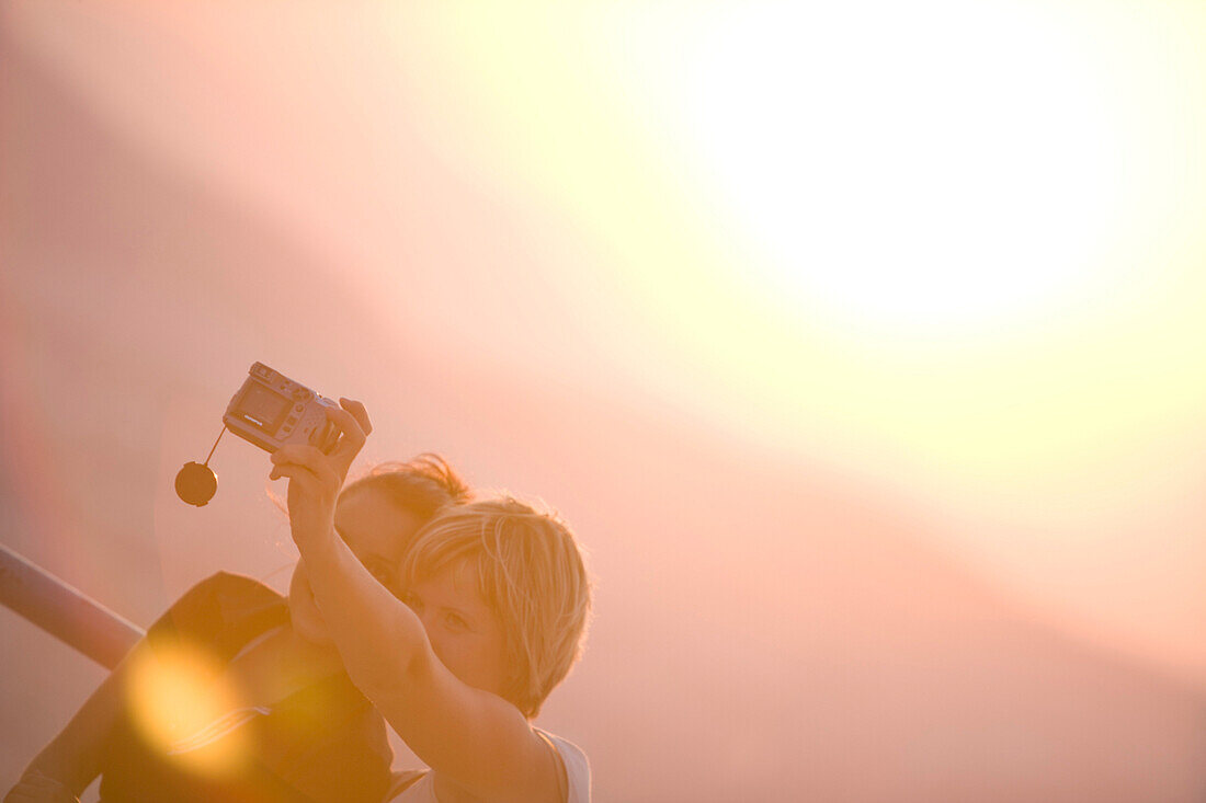 Zwei Frauen fotografieren sich bei Sonnenuntergang, Lykavittos Hügel, Athen, Griechenland
