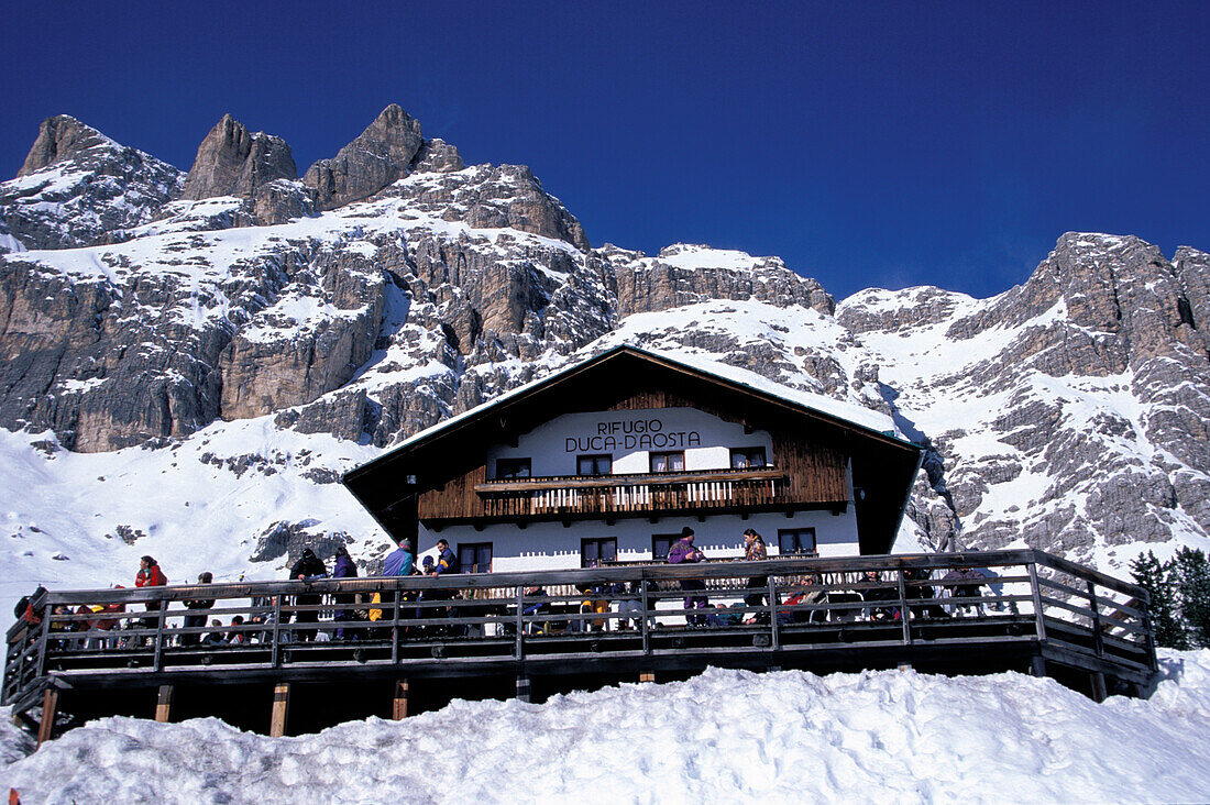 Blick von unten auf Hotel Duca d´Aosta vor verschneiten Bergen, Tofana, Cortina d´Ampezzo, Dolomiten, Südtirol, Italien, Europa