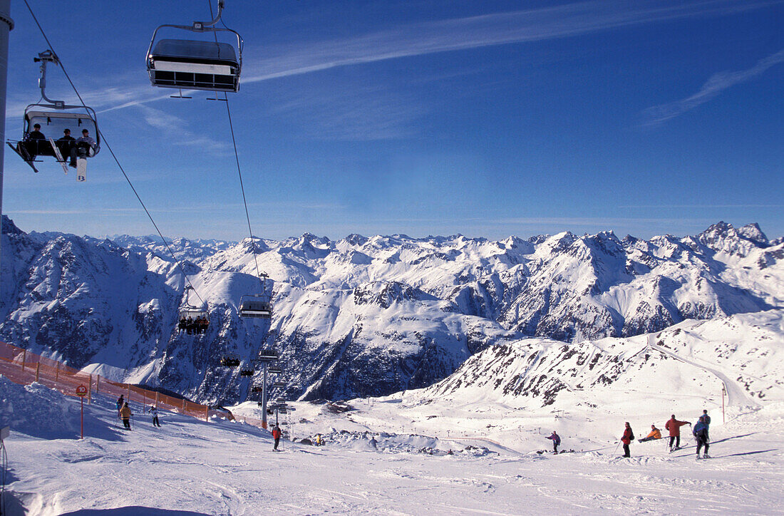 Sessellift und Skifahrer auf der Piste, Ischgl, Tirol, Österreich