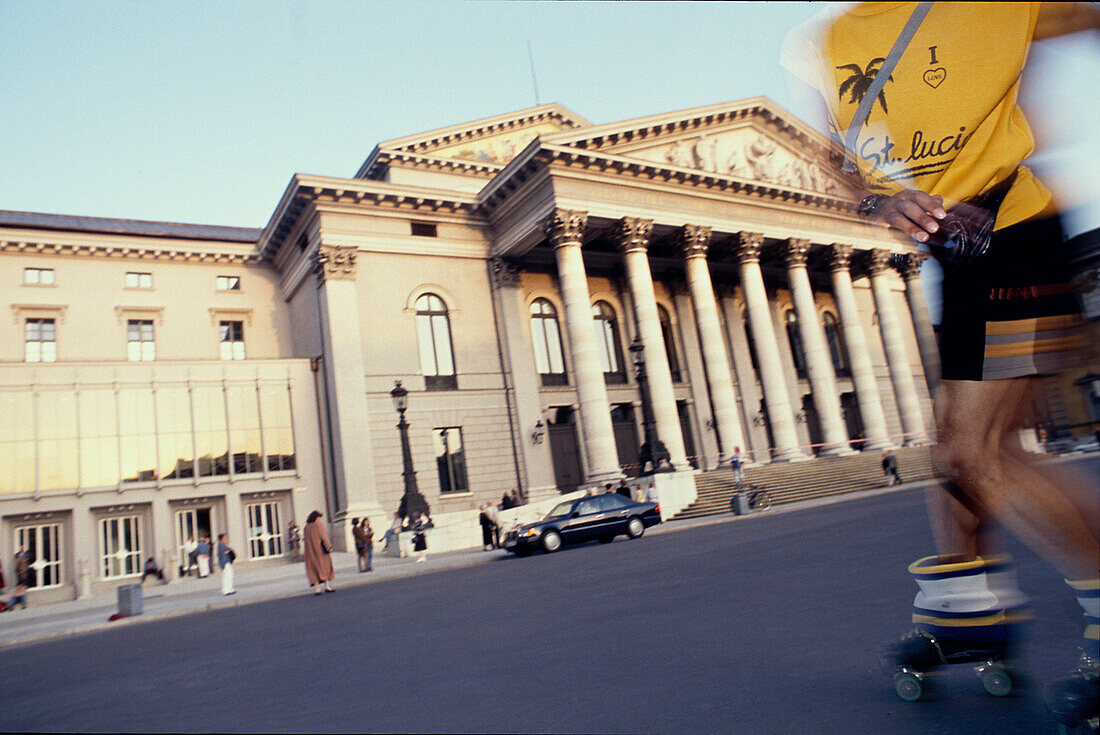 Mann fährt Rollschuhe vor dem Nationaltheater, München, Bayern, Deutschland