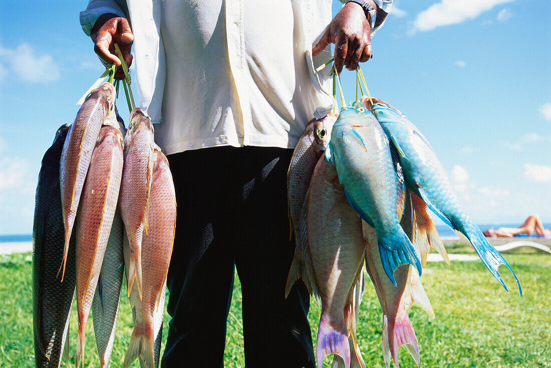 Fischer zeigt seinen Fang, Grand' Anse, Praslin, Seychellen