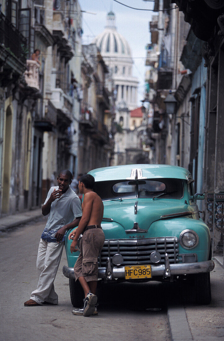 Zwei Männer lehnen an einem Oldtimer, La Habana Vieja, Havanna, Kuba