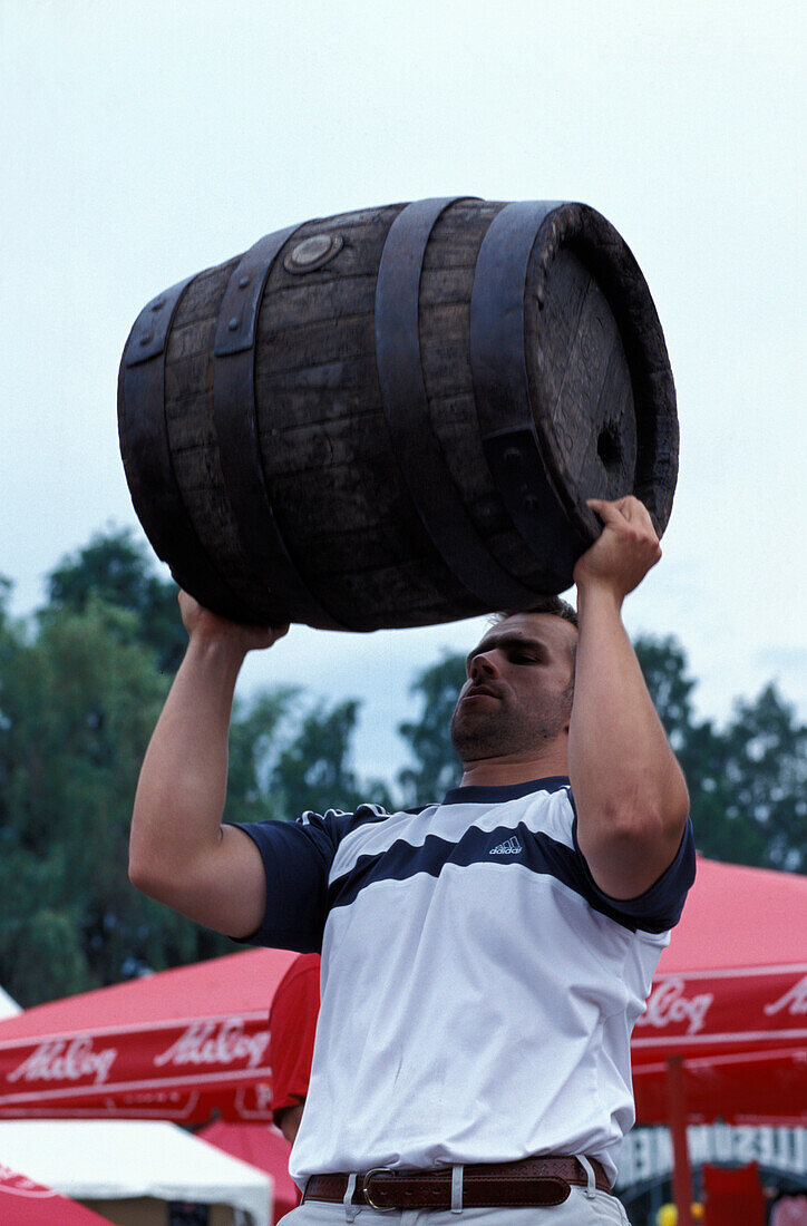 Mann stemmt Bierfass auf dem Bier Festival, Tallinn, Estland, Europa