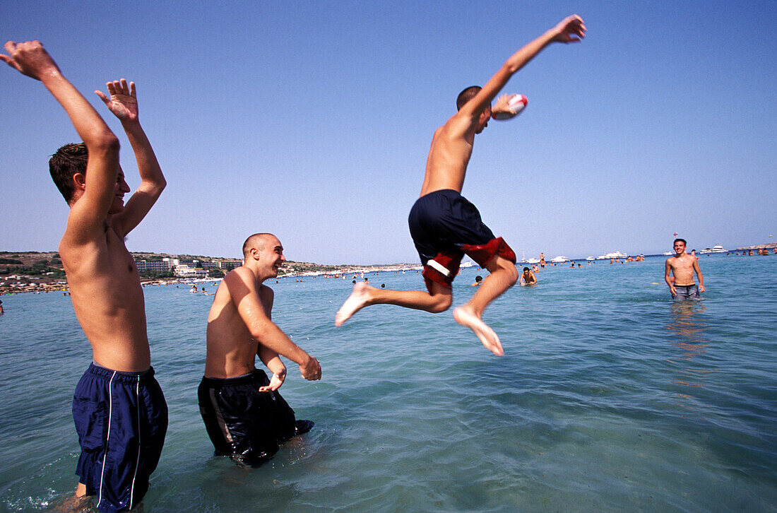 Junge Männer baden in der Mellieha Bucht, Malta