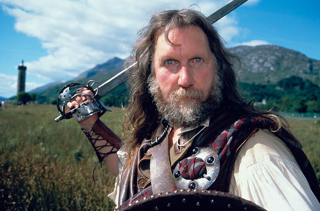 Mann in Tracht mit Schwert, Glenfinnan Highland Games, Invernessire, Schottland, Großbritannien