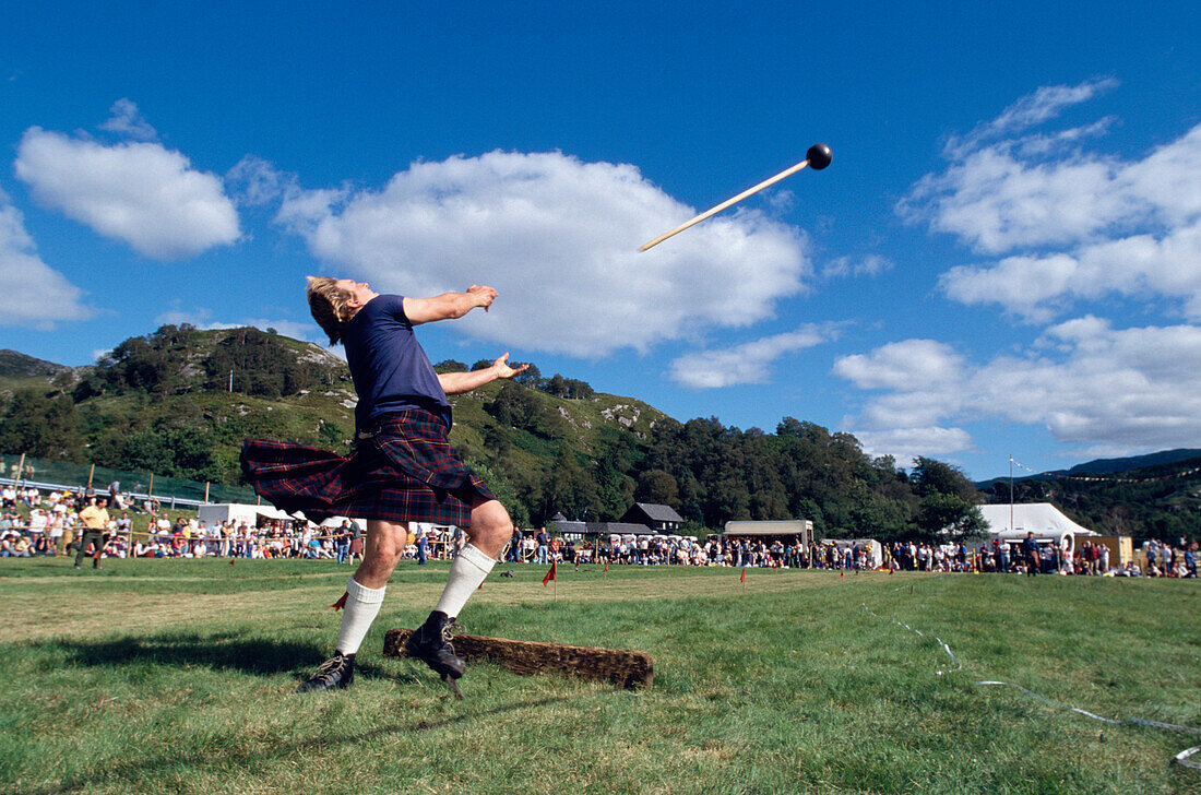 Mann im Kilt wirft einen Wurfhammer, Glenfinnan Highland Games, Invernesshire, Schottland, Grossbritannien, Europa