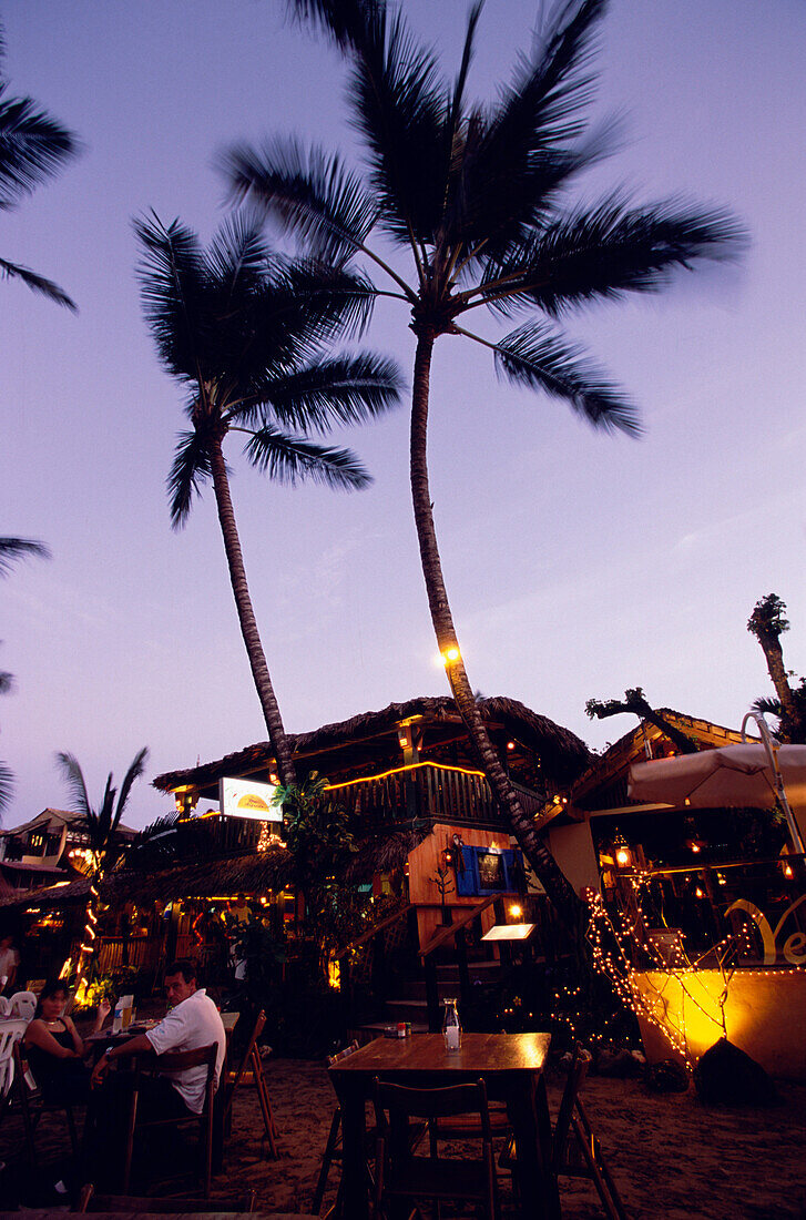 Restaurant in the evening, on the beach of Cabarete, People are sitting on plastic chairs, Dominican Republic