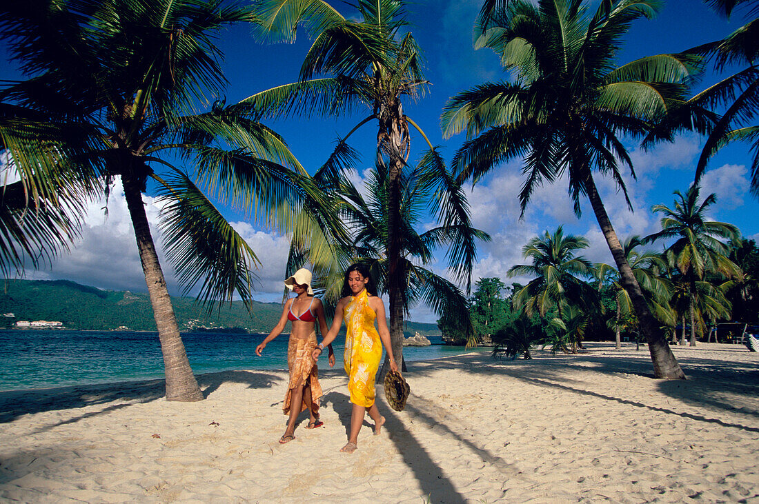 Zwei Frauen laufen am Strand entlang bei Cayo Levantado, Bahia de Samana, Dominikanische Republik, Karibik