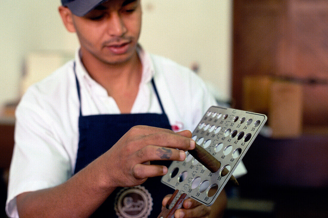 Leon Jimenes measuring cigars in a cigar factory in Santiago de los Caballeros, Dominican Republic, Caribbean