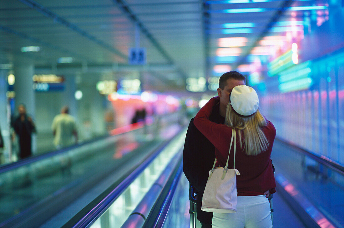Junges Paar beim Küssen, Laufband, Fahrsteig, Flughafen München, München, Deutschland