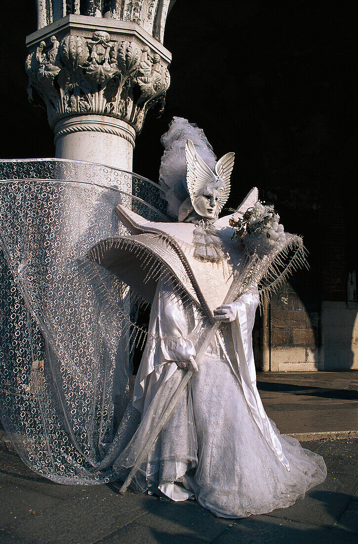 Verkleidete Person mit Maske vor einer Säule, Venedig, Venetien, Italien, Europa