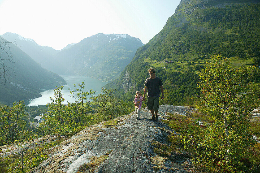 Vater und Tochter spazieren über Geiranger Fjord, More og Romsdal, Norway