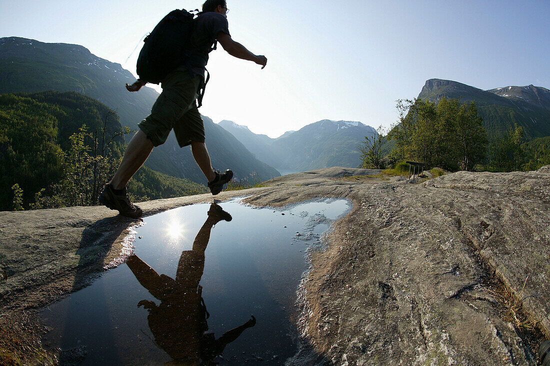 Hiker crossing stream, Dalsnibba, More og Romsdal, Norway