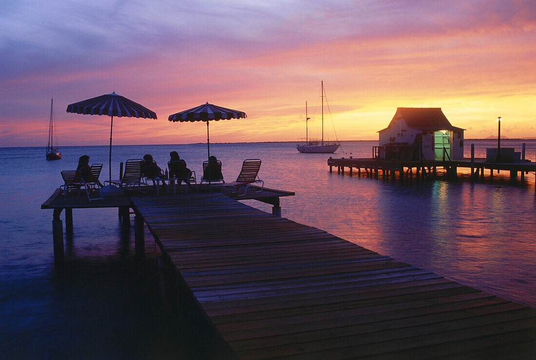 People watching a romantic sunset from wooden jetty, Divi Flamingo Beach Resort, Bonaire, ABC Islands, Netherlands Antilles, Antilles, Carribean