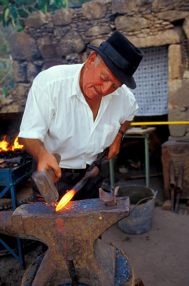 Blacksmith at the amboss, hammering iron, Canarian tradition, San Nicolas de Tolentino, Gran Canaria, Canary Islands, Spain