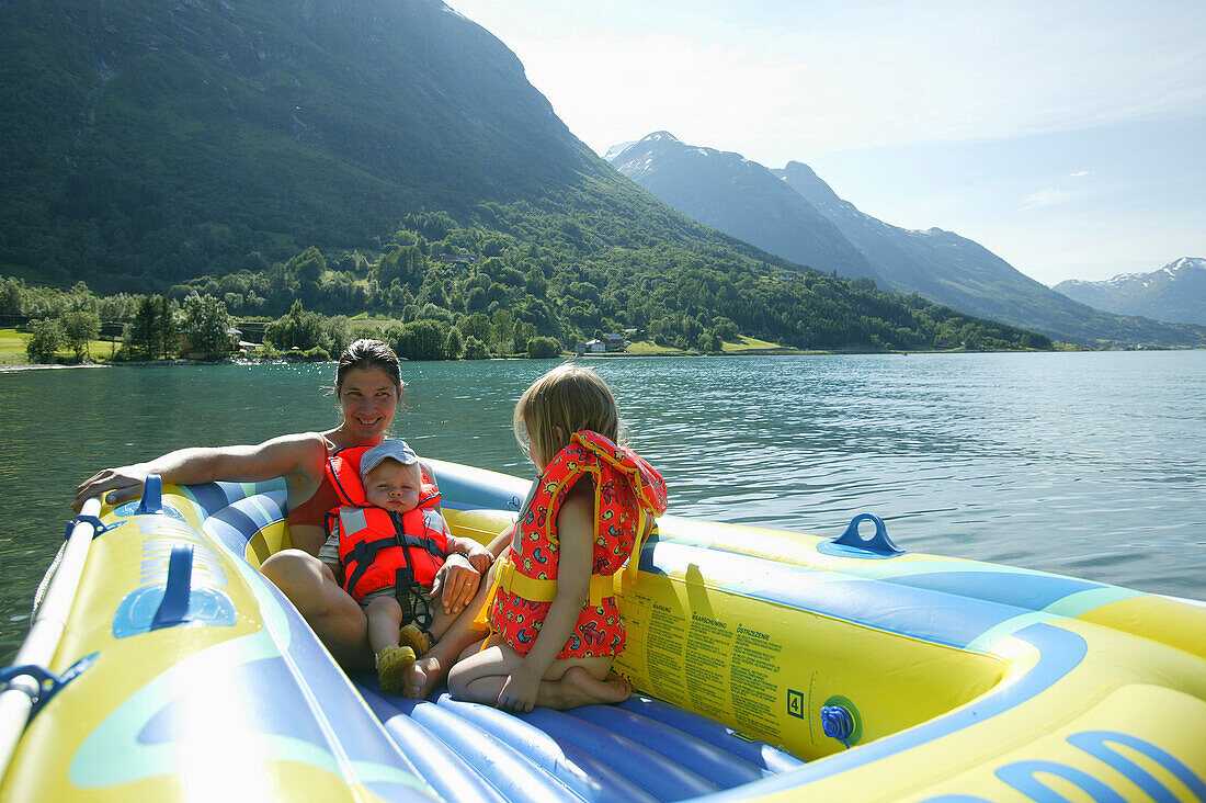 Woman with two children in a rubber boat on Lake Stryn, Sogn og Fjordane, Norway