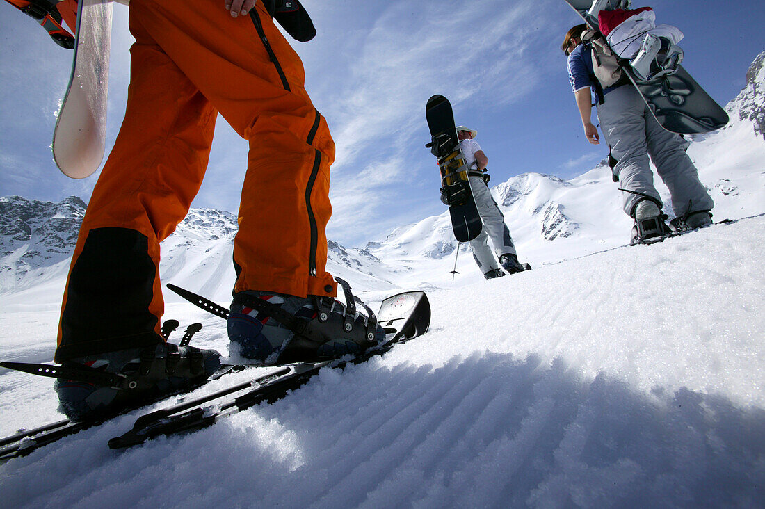 Three Snowboarder on feet, starting their ascend to Königsspitze near Ortler, Sulden, Italy