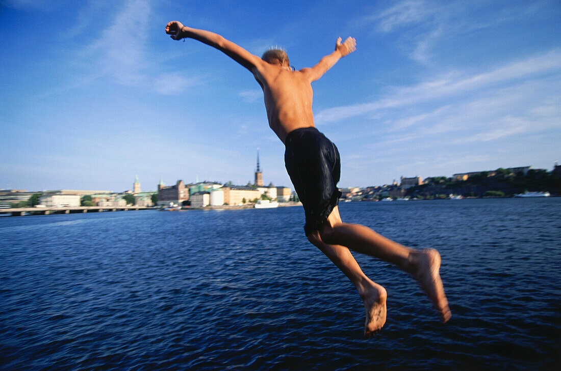 Boy jumping into the water, am Rathaus, Stockholm, Sweden, Europe