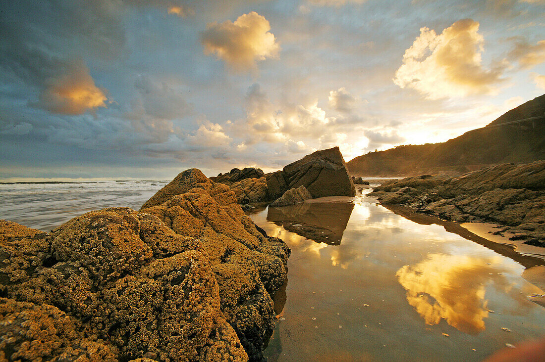 Rocky beach at sunset, Reflection of the sky in water, Garden Route, Western Cape, South Africa