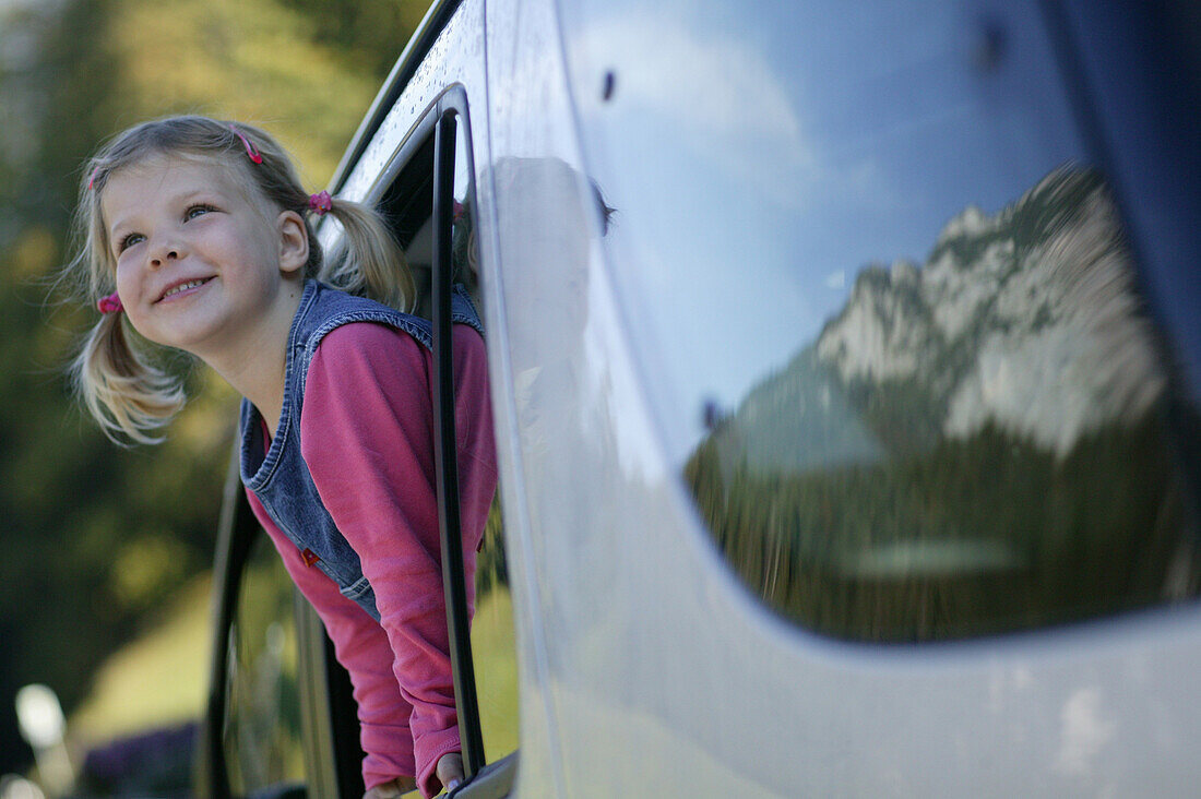 Young girl looking out the car window, Alpenstrasse, Reiteralpe, Ramsau, Germany