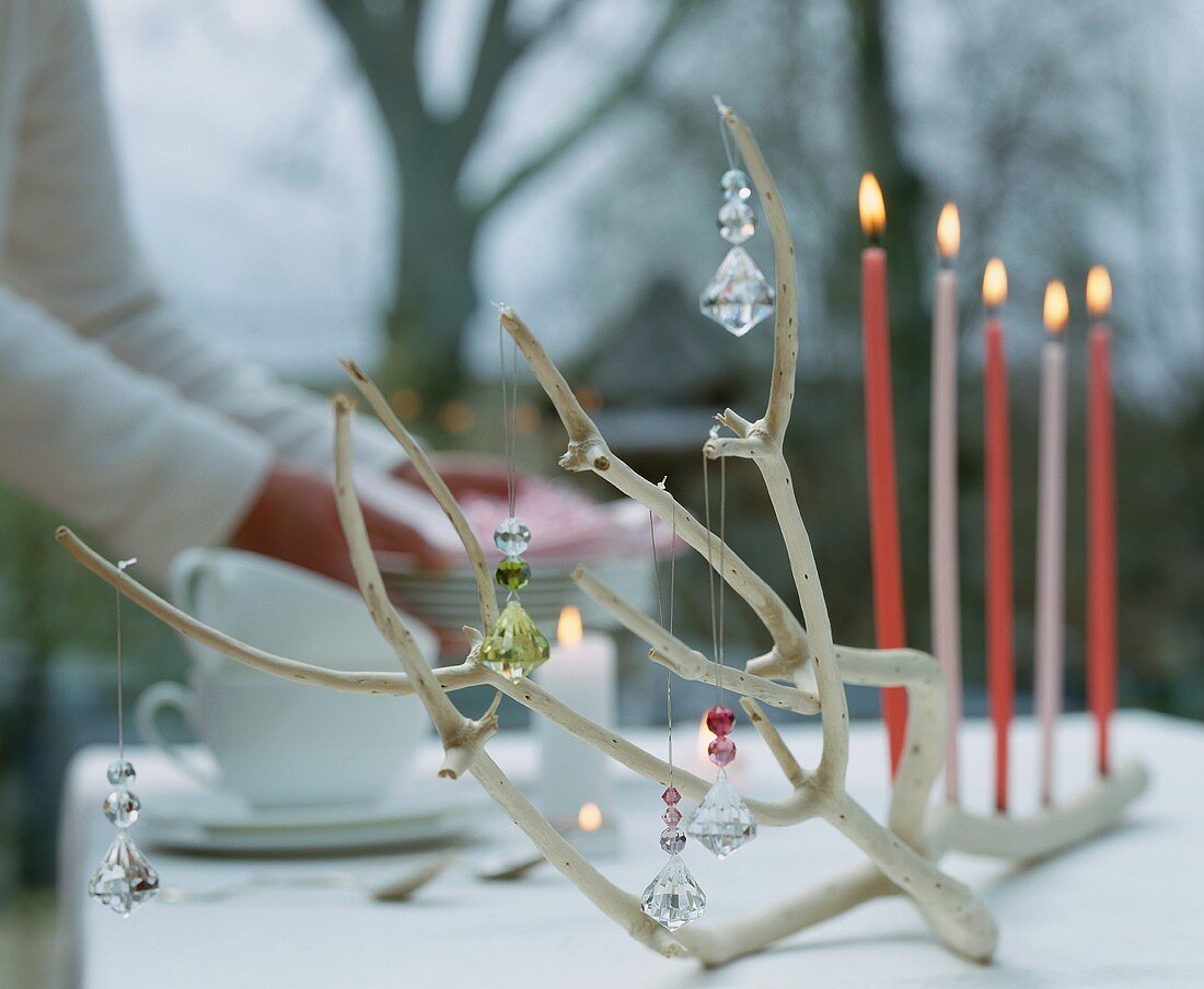 A branch decorated with glass pendants and candles