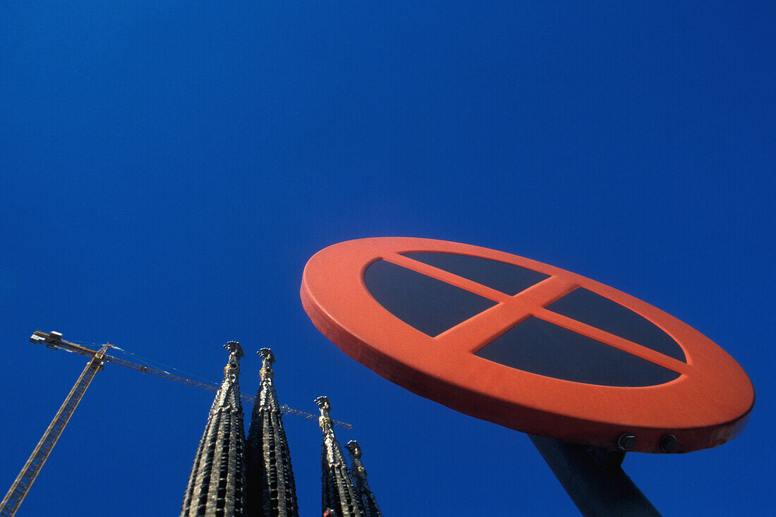 Traffic sign and the steeples of the basilica Sagrada Familia under blue sky, Barcelona, Spain, Europe