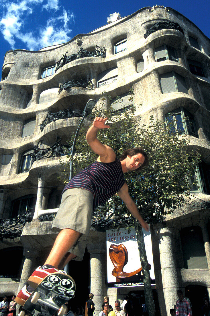 Junger Mann auf einem Skateboard vor dem Casa Mila, Barcelona, Spanien, Europa