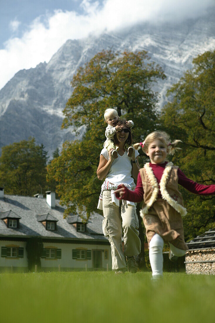 Mother with children on meadow, St.Bartholomä, Königssee, Berchtesgaden, Bavaria, Germany