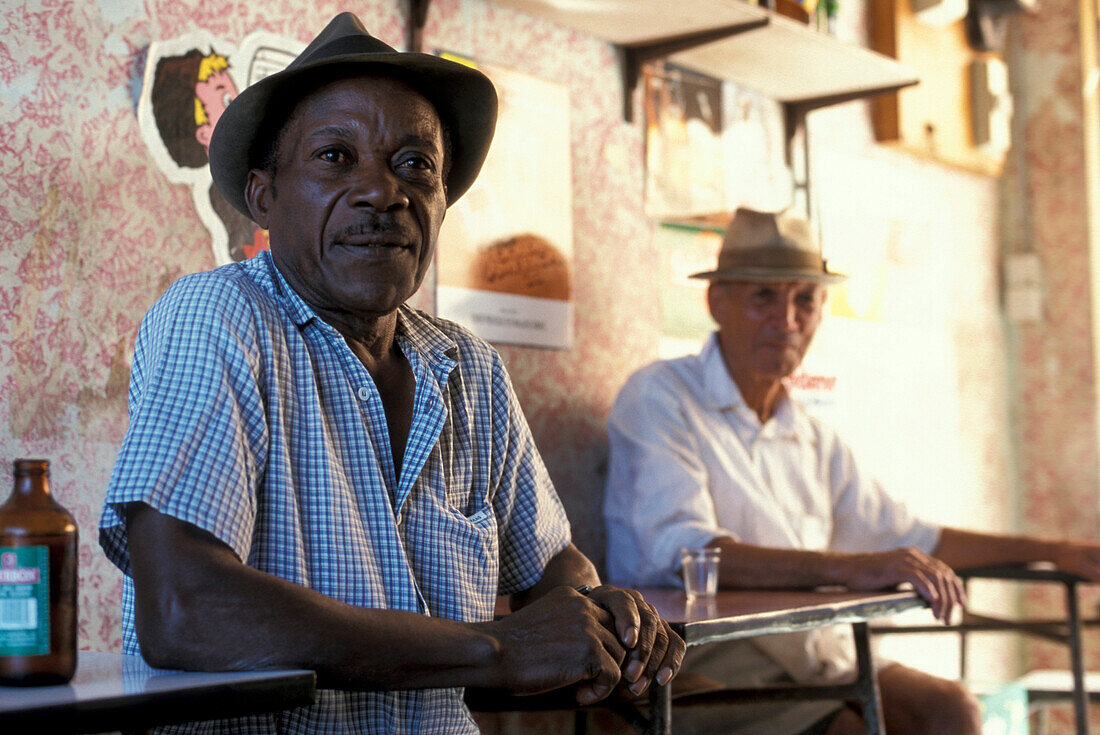 Two men sitting in a bar in St. Pierre, La Réunion, Indian Ocean