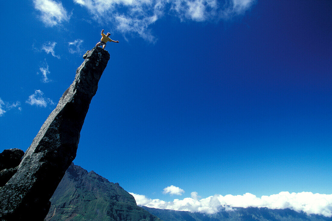 Kletterer steht oben auf einem Felsspitze, Blick Richtung Piton de la Fournaise und Formica Leo, Trois Salazie, Ille de la Réunion, Indischer Ozean