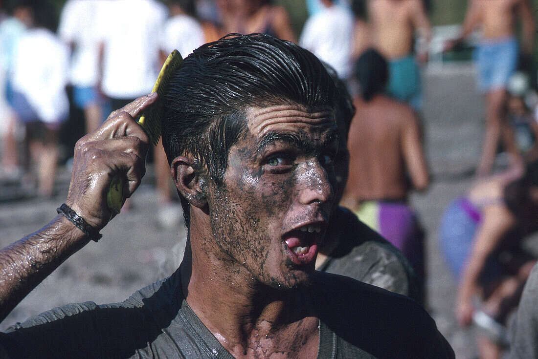 Jünge Mann im Schlamm kämmt seine Haare, Fest des Teiches, El Charco, San Nicolas de Tolentino Gran Canaria, Kanarische Inseln, Spanien