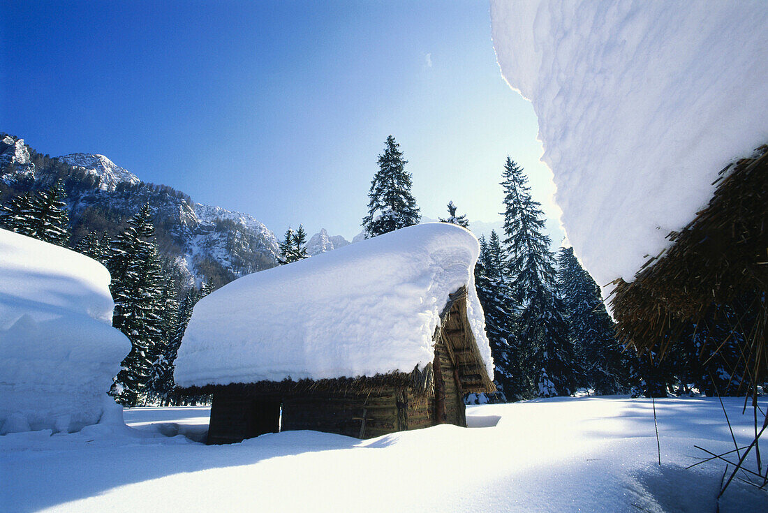 Winterlandschaft mit Holzhütten, Steinzeitdorf, Märchenwiese, Bodental, Loiblpass, Kärnten, Österreich