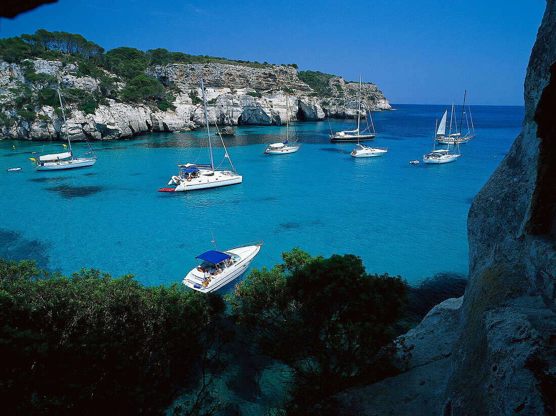 Sailing boats in a bay at Cala Macarella, Minorca, Spain