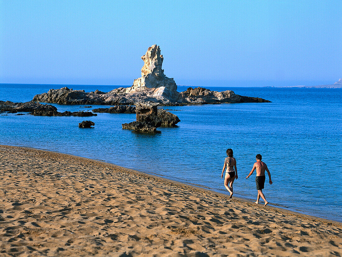 Couple walking along the beach, Cala Pregonda, Minorca, Spain