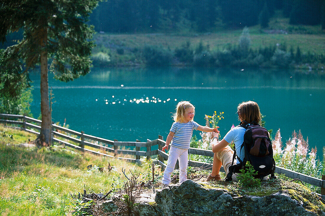 Tochter überreicht ihrer Mutter Wiesenblumen, St. Anton, Tirol, Österreich