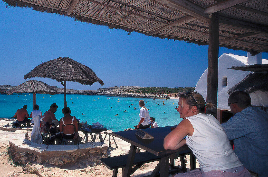 People sitting in a beach bar, Cala Binibeca, Minorca, Spain