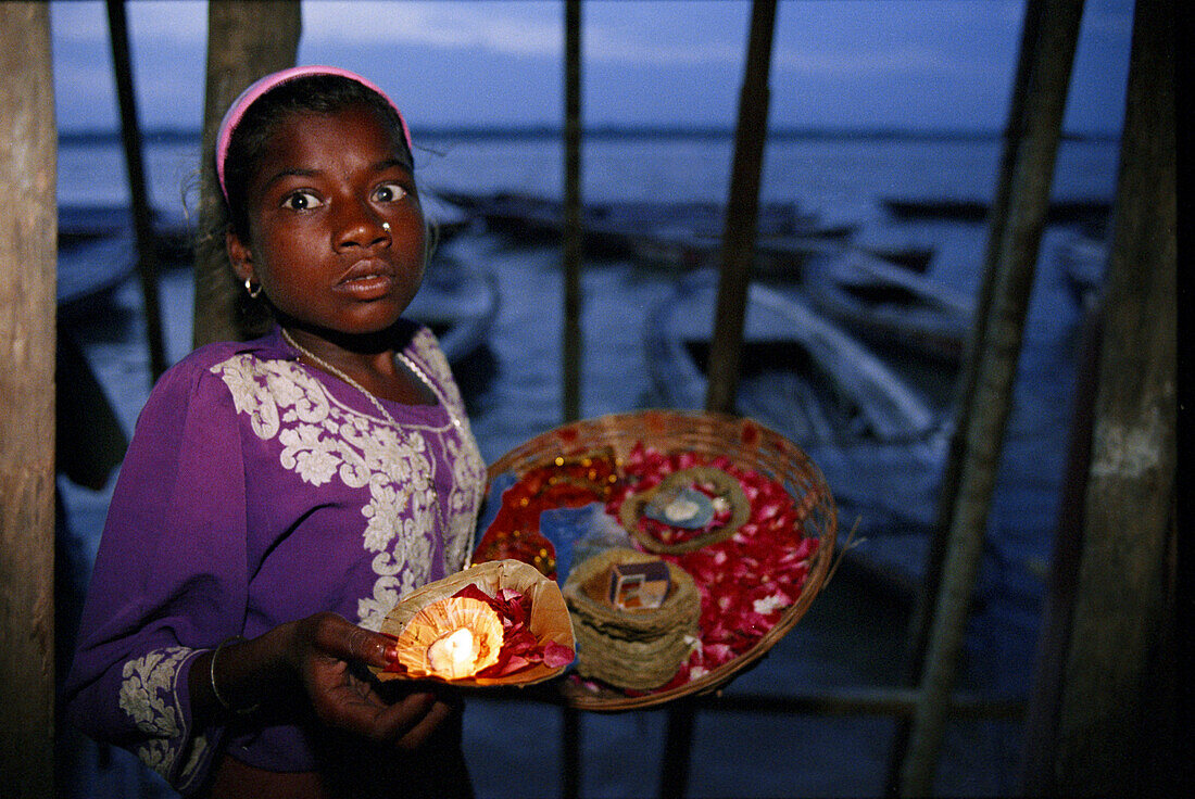 Girl with blossoms , Ganges river, Dasaswamedh, Varanasi, Benares Uttar Pradesh, India