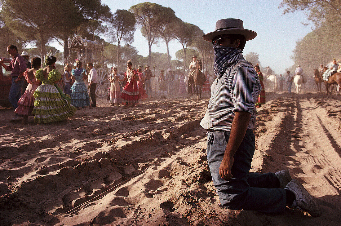 Pilger tragen einen Mundschutz auf der staubigen Raya Real, Andalusien, Spanien
