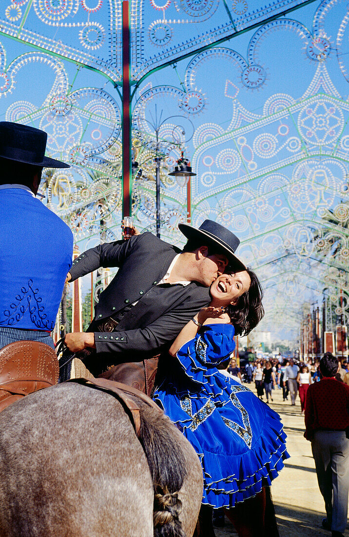 Mann küsst Frau auf Wange, Feria del Caballo, Jerez de la Frontera, Provinz Cadiz, Andalusien, Spanien