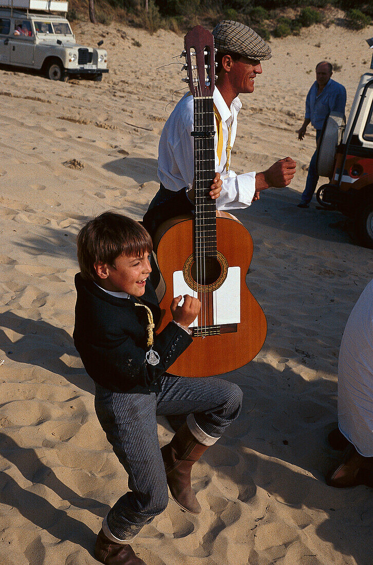 Pilgrim and boy with guitar at national park Donana, El Rocío, Andalusia, Spain, Europe
