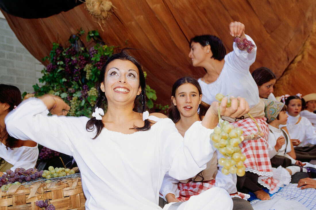 Frau wirft den Zuschauern Trauben zu, Weinfest, Impruneta, Chianti, Toskana, Italien