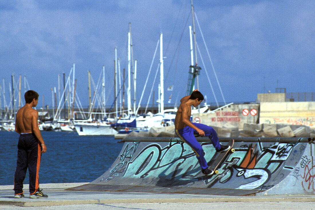 Boys with skateboard at a halfpipe at harbour, Port Olimpic, Barcelona, Spain, Europe