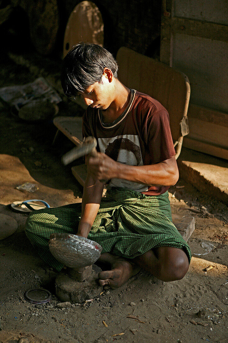 Burmese craftsman, metal beating, Handwerker, beating a metal bowl, begging bowl for monks, will be lacquered afterwards, Almosenschale für Moenche, die danach lackiert werden