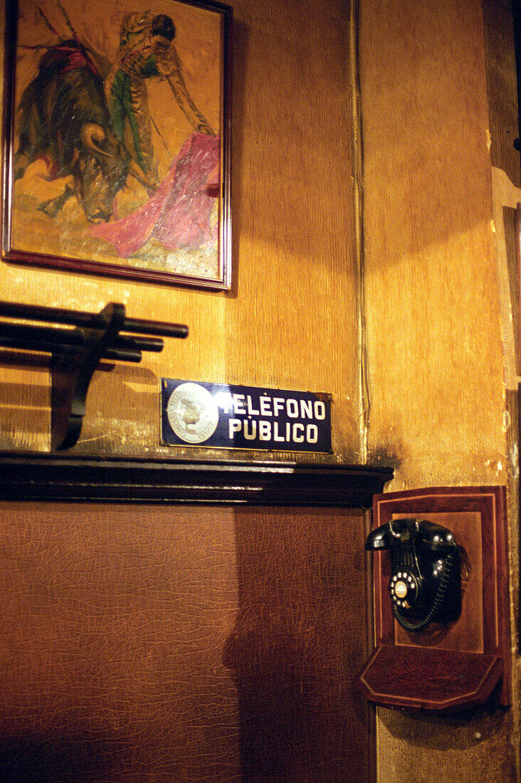 Old phone with picture of bullfight in background, Madrid, Spain