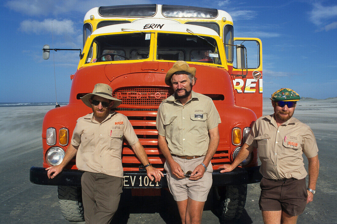 Drei Fremdenführer vor einem Truck an der Küste am tasmanischen Meer, Neuseeland, Ozeanien