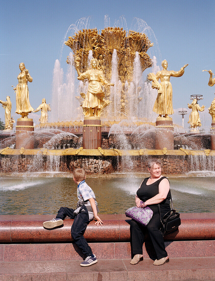 Besucher sitzen vor zentralem Brunnen, Allrussisches Ausstellungszentrum, Moskau, Russland