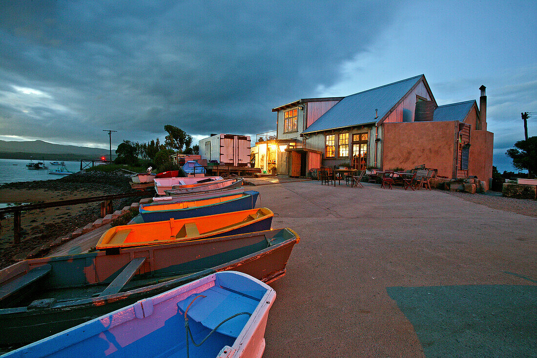 Fleurs Place, Moeraki, NZ, Coloured boats, fresh fish restaurant, waterfront at Moeraki, holiday and fishing village, South Island, New Zealand, Bunte Holzboote vor Restaurant, Fleurs Place im Fischer Dorf von Moeraki