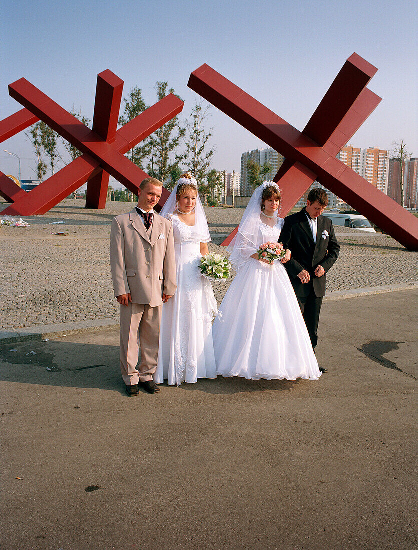 Zwei frischvermählte Paare posieren vor dem Kriegsdenkmal, Khimki, Moskau, Russland